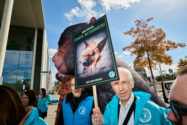 Ein überlebensgroßes Tiermodell und einige Demonstranten mit teils Plakaten