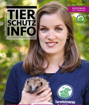 Das Titelbild des Vereinsmagazins, zeigt ein Tierpflegerin mit blauem T-Shirt mit Vereinslogo, die einen Igel in der Hand hält.