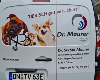 Die Rückseite des Fahrzeugs mit Werbung von Dr. Stefan Maurer, Versicherungsmakler GmbH.