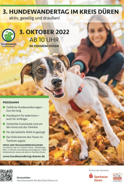 Das Poster zum Hundewandertag 2022 mit Text und dem Foto einer Frau mit Hund an der Leine im Herbstlaub.