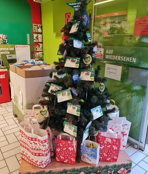 Weihnachtswunschbaum mit davor bunten Geschenktüten in einer Fressnapf-Filiale